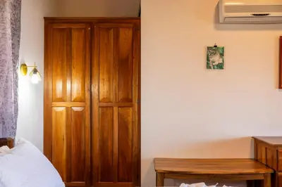 a bedroom with a wooden door next to a bed at Manys house in Ballena