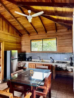 a kitchen with a table and a ceiling fan at Manys house in Ballena