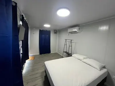 a bedroom with a white bed in a room at Cabinas Pacific Breeze in Parrita