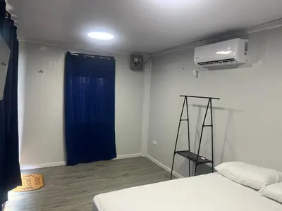 a bedroom with a bed and a blue curtain at Cabinas Pacific Breeze in Parrita