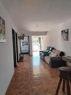 a living room with a couch and a tv in it at Casa Vacacional Brisas del Volcán Miravalles in Hacienda Guayabo