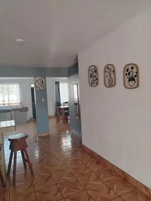 a living room with a table and four clocks on the wall at Casa Vacacional Brisas del Volcán Miravalles in Hacienda Guayabo