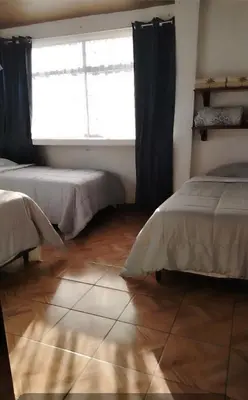 a bedroom with two beds and a large window at Casa Vacacional Brisas del Volcán Miravalles in Hacienda Guayabo