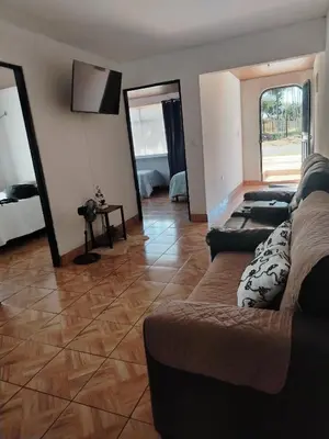a living room with a couch and a mirror at Casa Vacacional Brisas del Volcán Miravalles in Hacienda Guayabo