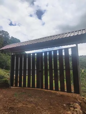 a wooden gate with a roof on top of a field at Mount & Wood in San Marcos