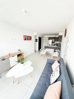 a living room with a blue couch and tables at Apartamento en San Pablo, Heredia, Costa Rica in San Pablo