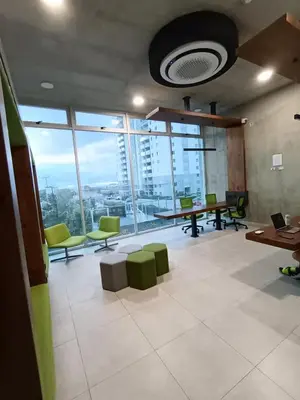 an office with a large room with tables and green chairs at Apartamento en San Pablo, Heredia, Costa Rica in San Pablo