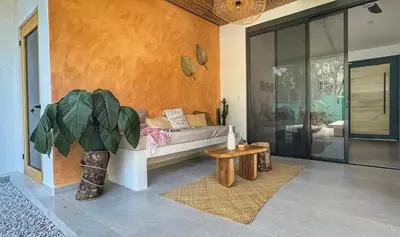 a living room with a bed and a potted plant at Casa Abana in Sámara