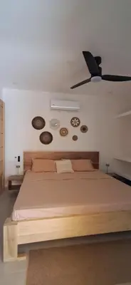 a bedroom with a bed with clocks on the wall at Casa Abana in Sámara