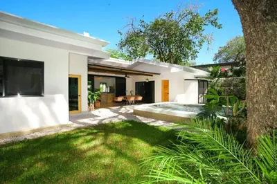 a backyard of a home with a pool and grass at Casa Abana in Sámara
