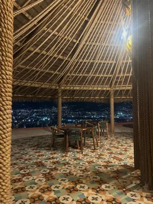 a room with a table and chairs under a roof at Apartamento Moderno con Vista Piscina Infinita Secrt Escalante in San Pedro