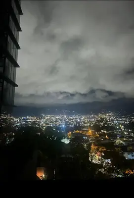 a view of a city at night at Apartamento Moderno con Vista Piscina Infinita Secrt Escalante in San Pedro