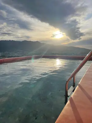 a view of a pool of water with the sun setting at Apartamento Moderno con Vista Piscina Infinita Secrt Escalante in San Pedro