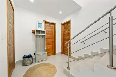 a hallway with stairs and a wooden door at Stunning Oceanview 3BR Condo Walk to Tamarindo in Tamarindo