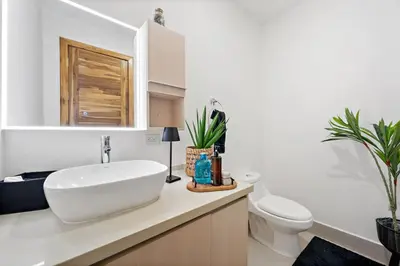 a bathroom with a white sink and a toilet at Stunning Oceanview 3BR Condo Walk to Tamarindo in Tamarindo