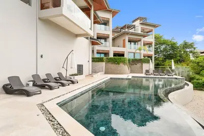 a swimming pool in the backyard of a house at Stunning Oceanview 3BR Condo Walk to Tamarindo in Tamarindo