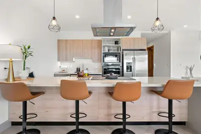 a kitchen with a large island with three bar stools at Stunning Oceanview 3BR Condo Walk to Tamarindo in Tamarindo