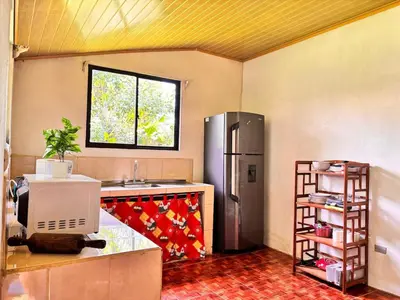 a kitchen with a sink and a refrigerator at Casa Sueño Verde, Juanilama De Pocosol in Muelle del Arenal