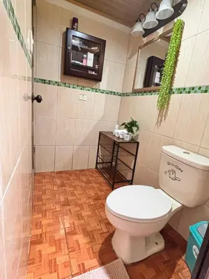 a bathroom with a toilet and a tv on the wall at Casa Sueño Verde, Juanilama De Pocosol in Muelle del Arenal