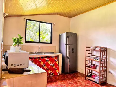 a kitchen with a stainless steel refrigerator and a window at Casa Sueño Verde, Juanilama De Pocosol in Muelle del Arenal