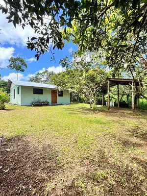 a white building with a large yard in front of it at Casa Sueño Verde, Juanilama De Pocosol in Muelle del Arenal