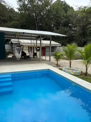 a blue swimming pool in front of a house at Private House with Pool 10 min from Playa Sámara in Nicoya