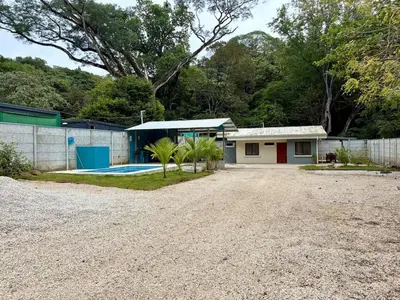 a home with a gravel driveway and a house at Private House with Pool 10 min from Playa Sámara in Nicoya
