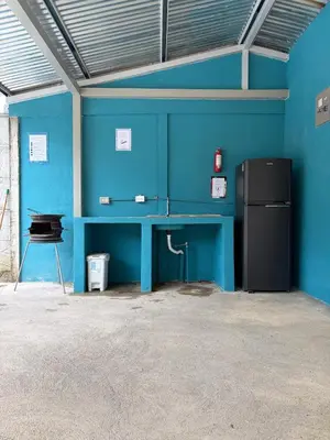 a blue room with a desk and a refrigerator at Private House with Pool 10 min from Playa Sámara in Nicoya
