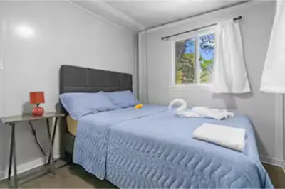 a bedroom with a blue bed and a window at Monkey Houses in Matapalo