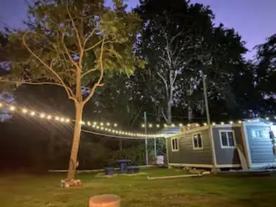 a camping site with a tree and lights at Monkey Houses in Matapalo