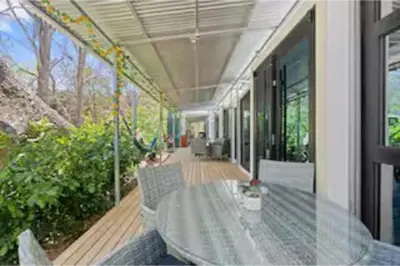 a porch of a house with a swing at Monkey Houses in Matapalo
