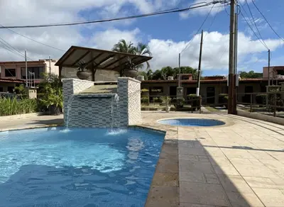 a swimming pool in a yard with a building at Apartamento Jaco Park,Jaco in Jacó