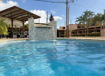 a large swimming pool with blue water at Apartamento Jaco Park,Jaco in Jacó