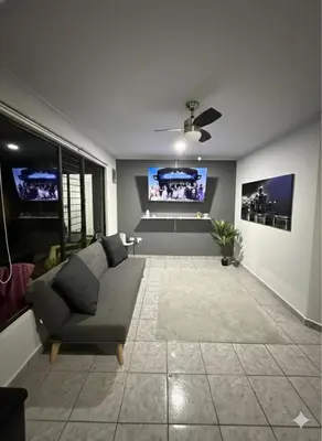 a living room with a couch and a flat screen tv at Apartamento Jaco Park,Jaco in Jacó