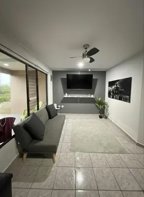 a living room with a couch and a flat screen tv at Apartamento Jaco Park,Jaco in Jacó