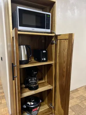 a microwave oven sitting on top of a wooden cabinet at Pura Tropic Lodge in Guayabal