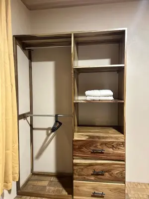 a walk in closet with wooden shelves and towels at Pura Tropic Lodge in Guayabal