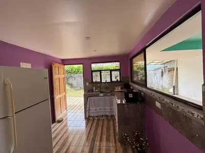 a kitchen with purple walls and a refrigerator at Casa La Lima, Bagaces in Bagaces