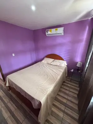 a bedroom with a purple wall and a bed at Casa La Lima, Bagaces in Bagaces