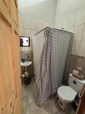 a bathroom with a toilet and a shower curtain at Casa La Lima, Bagaces in Bagaces