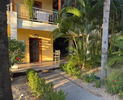 a yellow house with a porch and a balcony at Lavinia Apartment Playa Potrero in Potrero