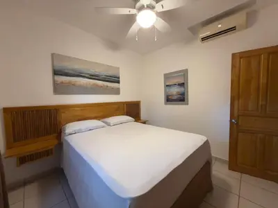 a bedroom with a bed and a ceiling fan at Lavinia Apartment Playa Potrero in Potrero