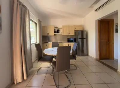 a kitchen with a table and chairs and a refrigerator at Lavinia Apartment Playa Potrero in Potrero