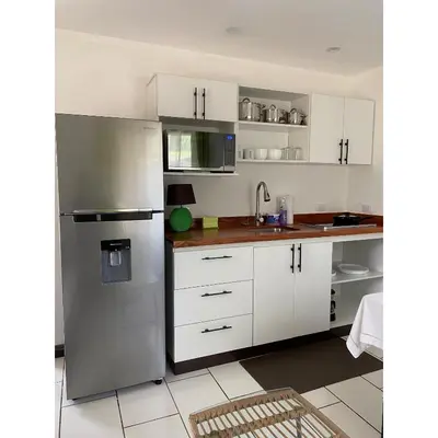 a kitchen with white cabinets and a stainless steel refrigerator at Apartamento Manzu in Santa Cruz