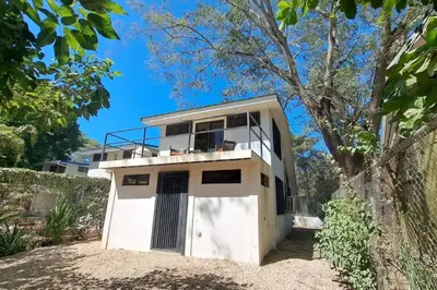 a white house with a balcony on top of it at Cozy Jungle Loft Close to Tamarindo and Surf Beaches in Santa Rosa