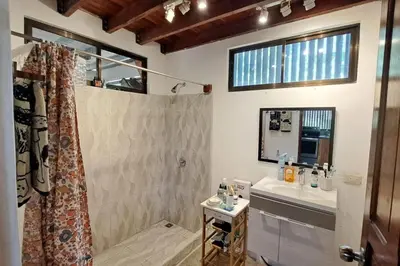 a bathroom with a shower and a sink and a mirror at Cozy Jungle Loft Close to Tamarindo and Surf Beaches in Santa Rosa
