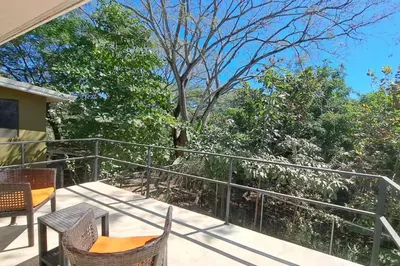 a balcony with chairs and a view of trees at Cozy Jungle Loft Close to Tamarindo and Surf Beaches in Santa Rosa