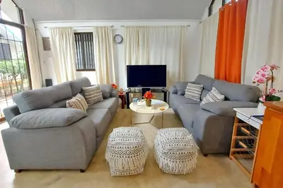 a living room with two couches and a tv at Cozy Jungle Loft Close to Tamarindo and Surf Beaches in Santa Rosa