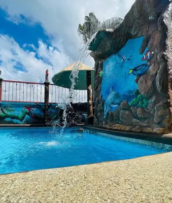 a pool with a water fountain in front of a mural at Spring House in Ángeles