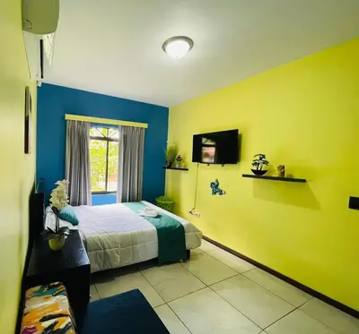 a bedroom with yellow and blue walls and a bed at Spring House in Ángeles